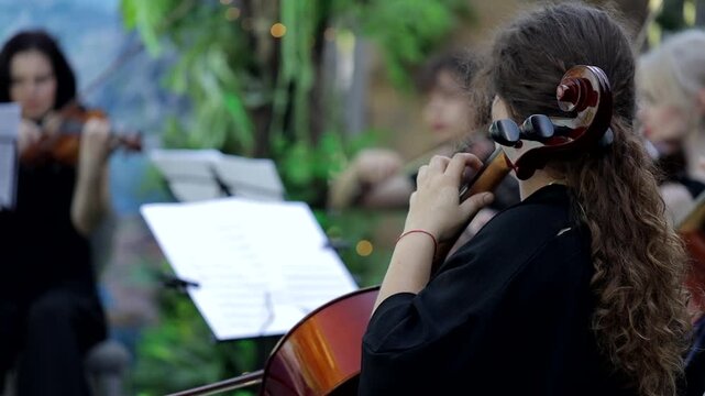 Violin concert. Musician playing cello outdoors. Cellist play music for the wedding. Wedding music concept