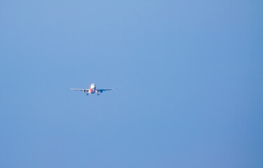 The plane lands over the sea at Phuket airport. A passenger plane lands on Mai Khao Beach, a popular tourist attraction.