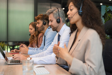 Attractive positive young businesspeople and colleagues in a call center office.