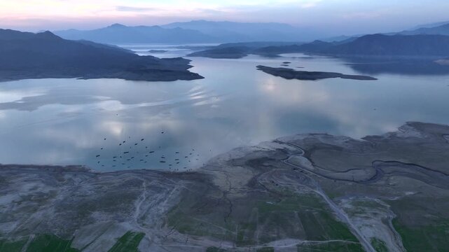 Khanpur Dam Lake Aerial Sunset View, Pakistan. Boats in water and Mountainsd on Background