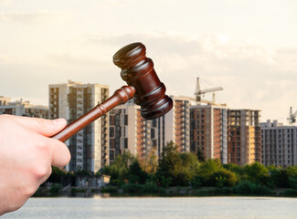 Judge's gavel against the background of residential high-rise buildings. Real estate court...