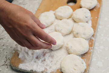 Women's hands make cheesecakes from cottage cheese. Homemade food. Healthy breakfast. Female chef is making cake