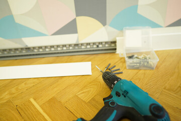 Baseboards fit to walls in room. Fitting Skirting Boards using an electric drill. Fit Skirting...