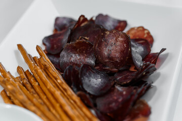 Sliced meat with sauce and breadsticks