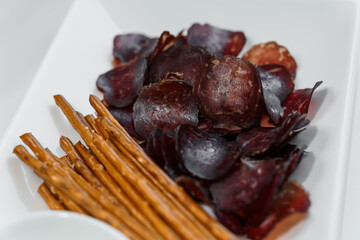 Sliced meat with sauce and breadsticks