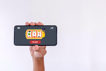Hand holding a mobile phone with online casino gambling on the screen.