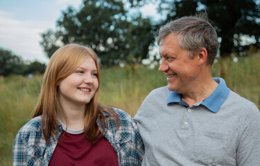 Fototapeta premium father and teenage daughter relaxing together outdoors in summer