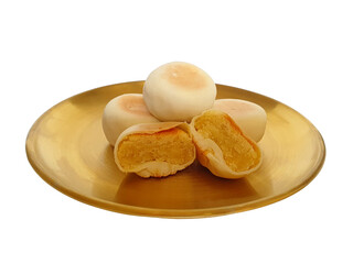 Classic bakpia (Bakpia Pathok) with green beans filling, whole and half sliced on golden plate isolated on white background. Its typical food souvenir of Yogyakarta, Indonesia.