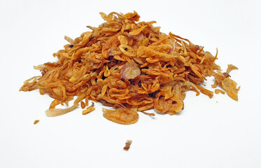 Deep fried shallots for garnishing isolated on white background with clipping path. Pile of fried sliced red onions.
