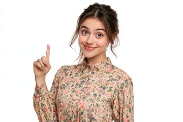 A cheerful young woman in a blouse, making a playful gesture with one finger pointing to the side, against a white background that offers plenty of space for creative content 