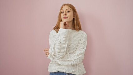 A thoughtful young woman in a white sweater poses against a pink background, exuding a casual and approachable vibe.