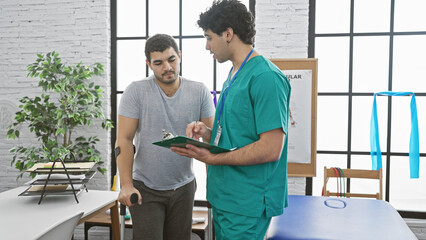 Physiotherapist and patient discuss rehabilitation in a modern physiotherapy clinic with exercise equipment.