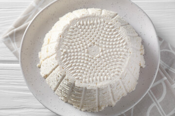 Tasty ricotta (cream cheese) on white wooden table, top view