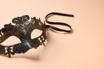 Beautiful carnival mask on beige background, space for text