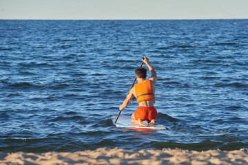 A man is sailing on a supp at sea