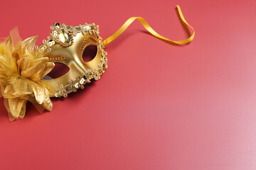 Beautiful carnival mask on red background, space for text