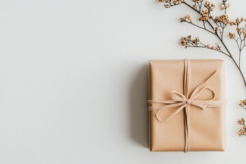 A neatly wrapped gift with a bow placed on a plain white table, with a large area of empty space around it, drawing attention to the simplicity and elegance of the holiday package. 