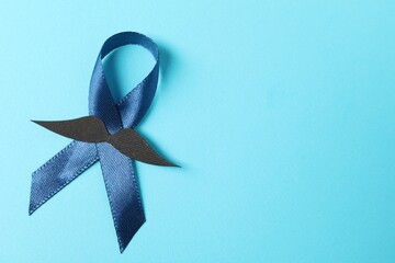 Dark blue ribbon and fake mustache on color background, top view with space for text. Prostate...