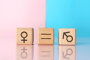 Gender equality concept. Cubes with male and female symbols on color background