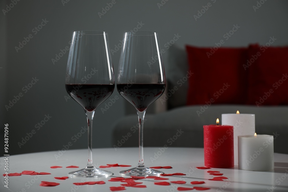 Canvas Prints Burning candles, wine in glasses and paper hearts on table indoors