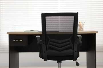 Black chair, laptop and desk in office