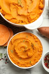 Delicious mashed sweet potatoes, spices and vegetable on white marble table, top view