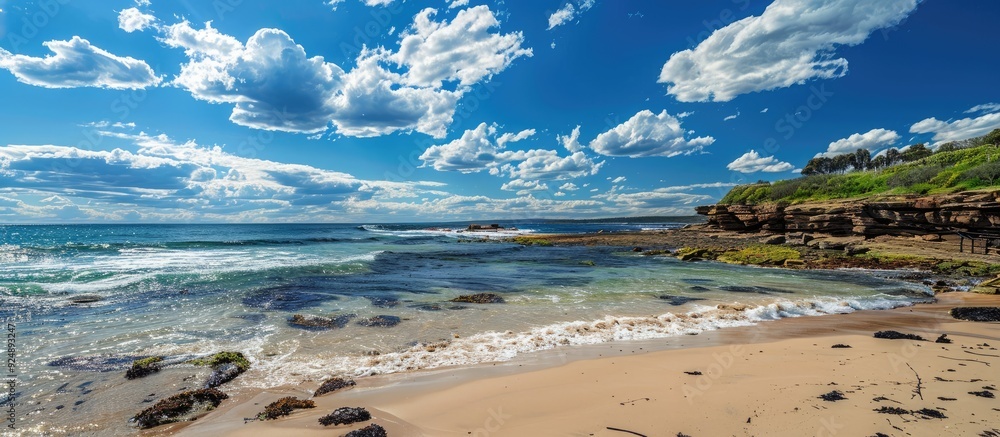 Poster scenic coastal view with clear blue skies and fluffy clouds on a sunny day featuring a wide copy spa