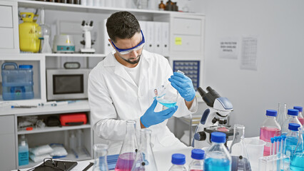 Handsome man conducting experiments in a laboratory setting, surrounded by scientific equipment.