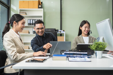 Business documents on office table with tablet and laptop computer and chart and two colleagues discussing data in office.