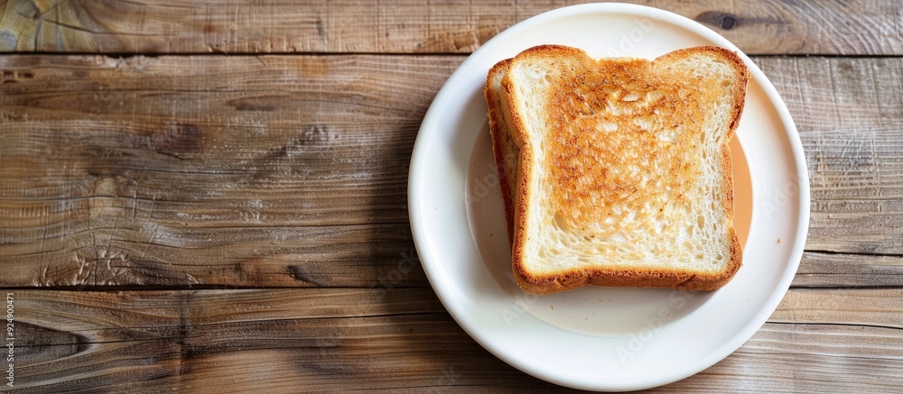 Poster place the toasted bread on a white plate over a wooden table with a designated copy space image
