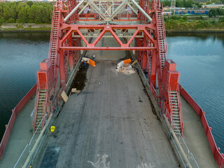 Construction workers repairing a bridge over river
