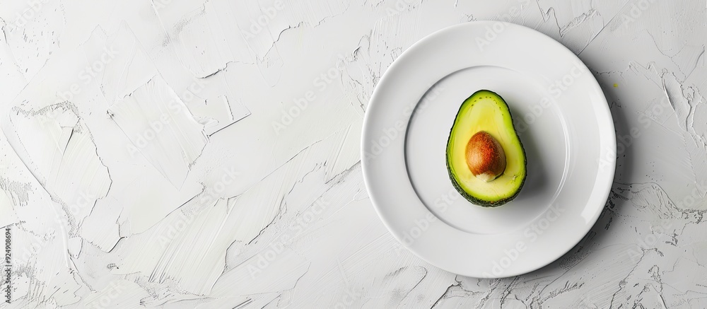 Poster Fresh avocado fruit slice placed on a white plate with copy space image