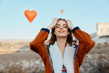Woman gazing at heartshaped balloon floating in the sky with a look of wonder and awe