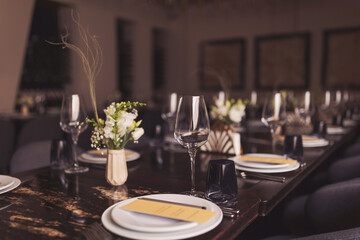 Beautifully served festive table. served table with white tablecloth. white plates, wine glass, fork, knife. luxury tableware beautiful table setting in restaurant. Table set for an event party 