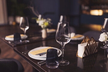 Beautifully served festive table. served table with white tablecloth. white plates, wine glass, fork, knife. luxury tableware beautiful table setting in restaurant. Table set for an event party 