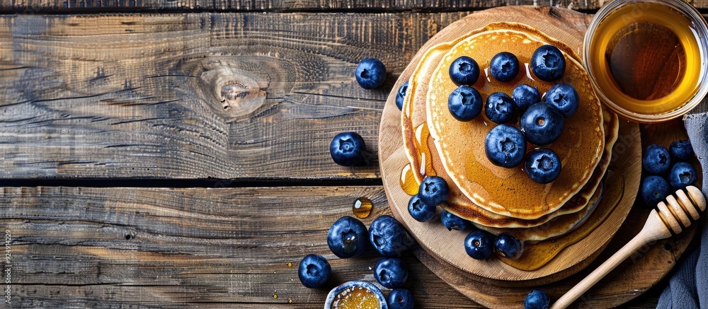 Poster A tempting display of pancakes topped with honey and blueberries on a wooden backdrop offering copy space image