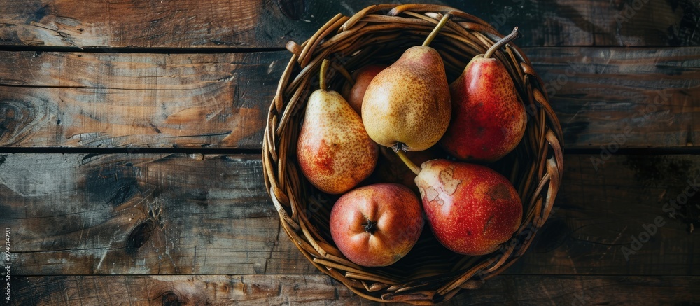 Poster copy space image of organic ripe pears displayed in a rustic basket on a wooden table promoting heal
