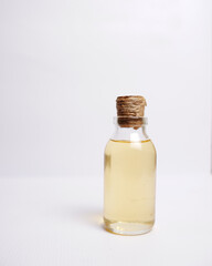 coconut oil in a small bottle on a white isolated background