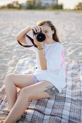 Woman photographer sitting on the beach