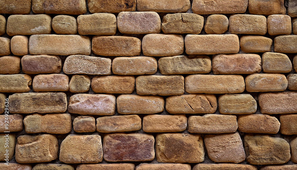 Poster textured pattern of interlocking multi-sized sandstone bricks in earthy tones of beige tan brown, st