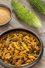 Punjabi-style bitter gourd curry (Karela Sabji in Hindi) with onion, dry mango powder, and spices....