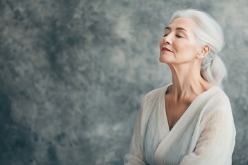 An older woman enjoying a moment of tranquility with closed eyes in a serene indoor setting