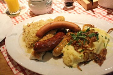 German cuisine: bratwurst (grilled pork sausages), mashed potatoes and sauerkraut (sour cabbage) in Munich, Germany