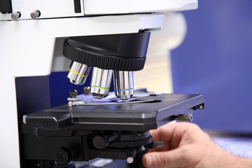 A microscope with a light on it, Man medical Doctor or research scientist looking through a microscope in a laboratory.science experiments, laboratory glassware containing chemical liquid for research