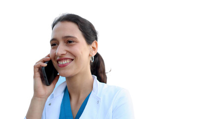 Young female doctor standing in front of her medical clinic and talking on mobile phone