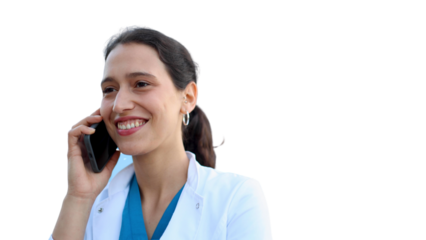 Young female doctor standing in front of her medical clinic and talking on mobile phone