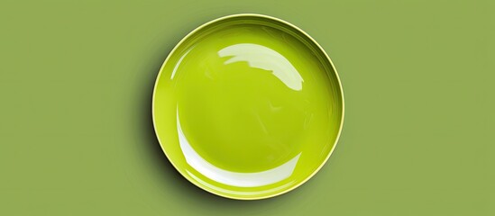 Top view of an isolated colored background featuring an empty round green plate for food Unoccupied dish with space for your design. with copy space image. Place for adding text or design