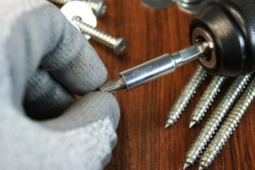 Work process of the builder. Removing the Torx bit from the adapter