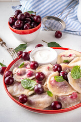 Traditional West Europe Dumplings with Cherries, ukrainian, polish vegan Cherry Pierogi, Sweet berry fruit Vareniki, ravioli with sour cream and sugar powder