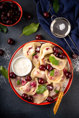 Traditional West Europe Dumplings with Cherries, ukrainian, polish vegan Cherry Pierogi, Sweet berry fruit Vareniki, ravioli with sour cream and sugar powder